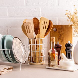 Beautiful kitchen background modern kitchen countertop with a set of kitchen utensils, plate dryer, decorative elements. Front view. Brick white wall
